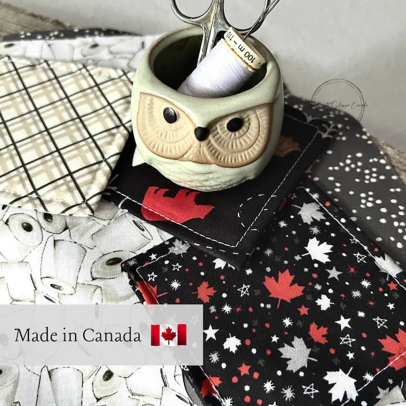 Made in Canada image with scissors and a spool of thread sitting on Canadian fabric.