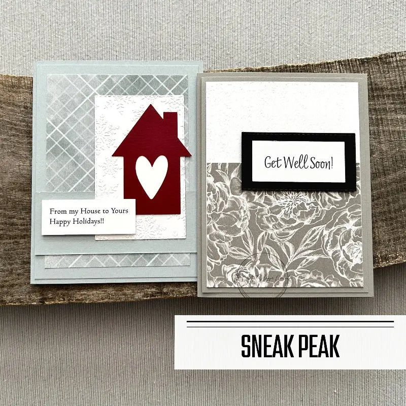 2 of the finished cards, from this card making kit, are sitting on a wooden board.