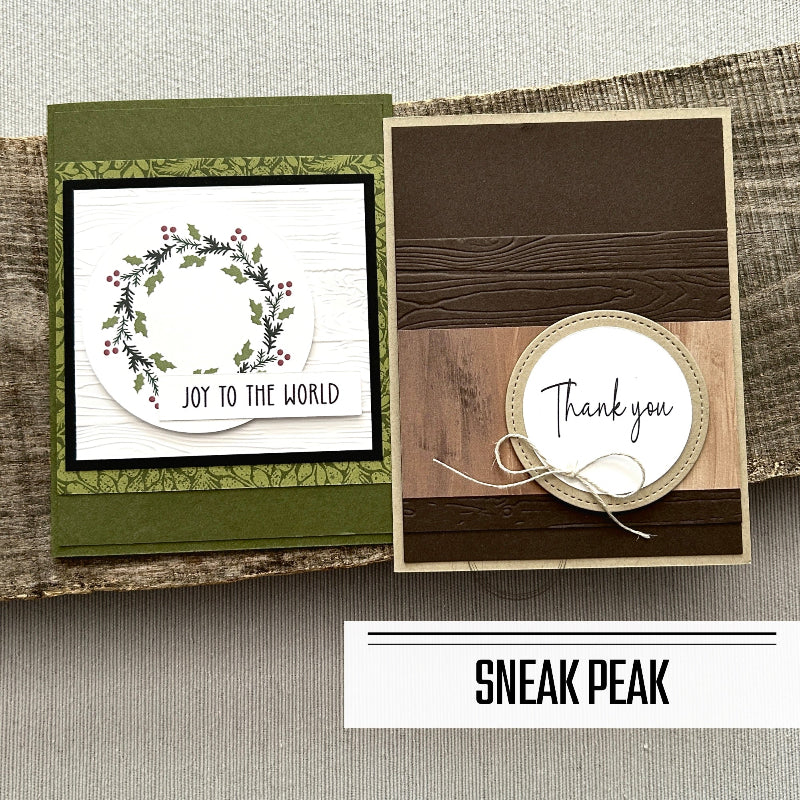 2 of the finished cards, from this card making kit, are sitting on a wooden board.