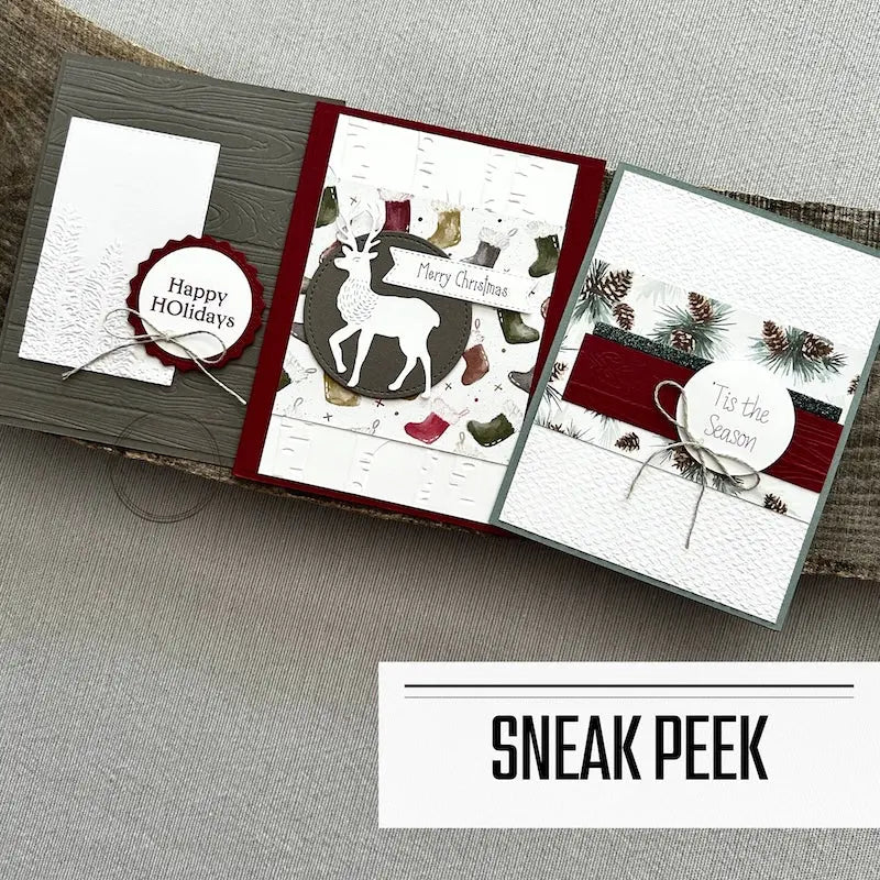 3 finished cards, from this card making kit, are sitting on a wooden board.