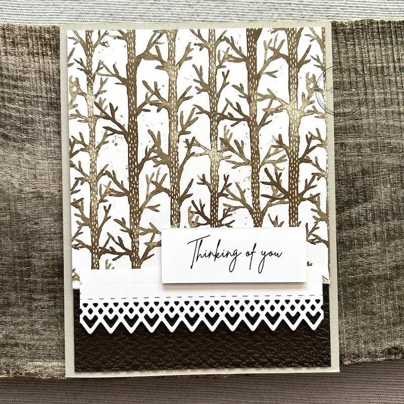 A finished card, from this card making kit, sitting on a wooden board.