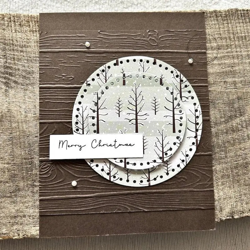A finished card, from this card making kit, sitting on a wooden board.