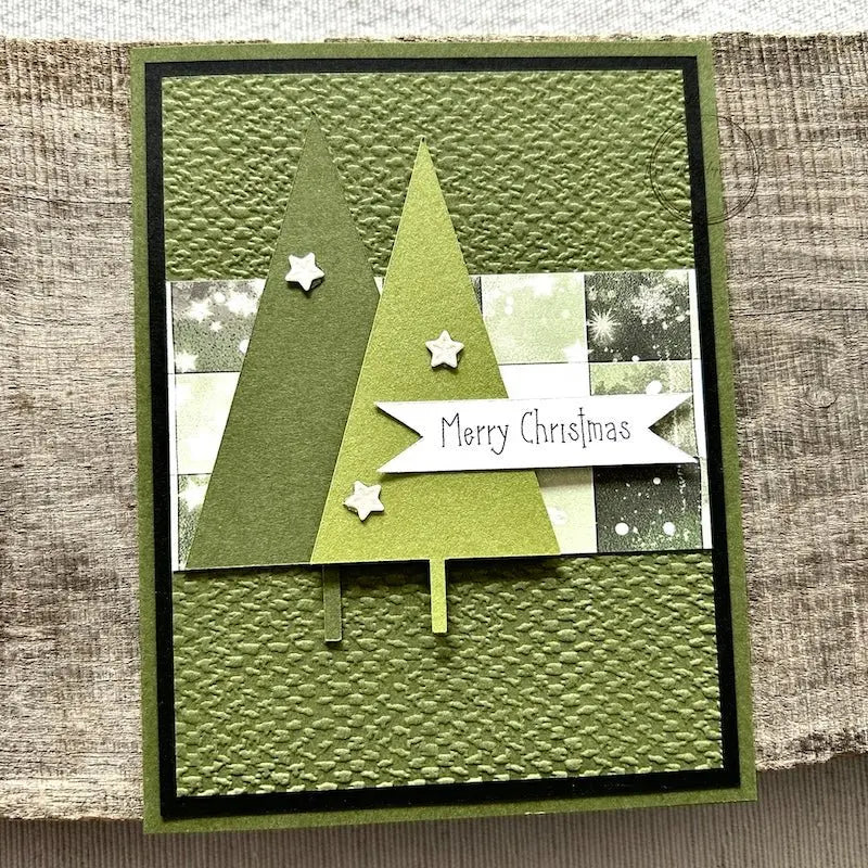 A finished card, from this card making kit, sitting on a wooden board.