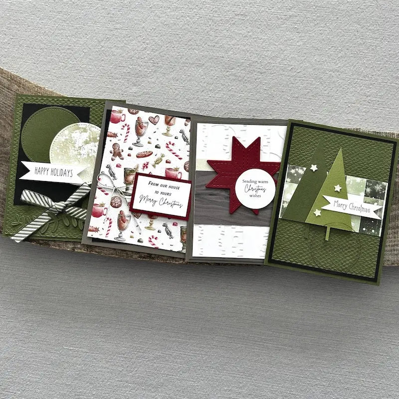 There are 4 finished cards, sitting on a wooden board, to show the finished cards that are included in this card making kit.