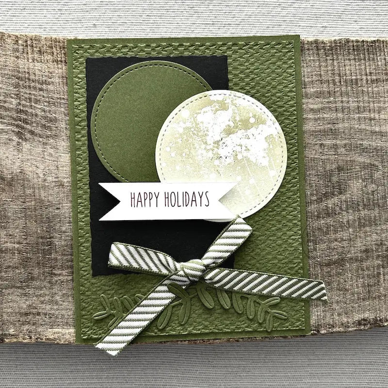 A finished card, from this card making kit, sitting on a wooden board.