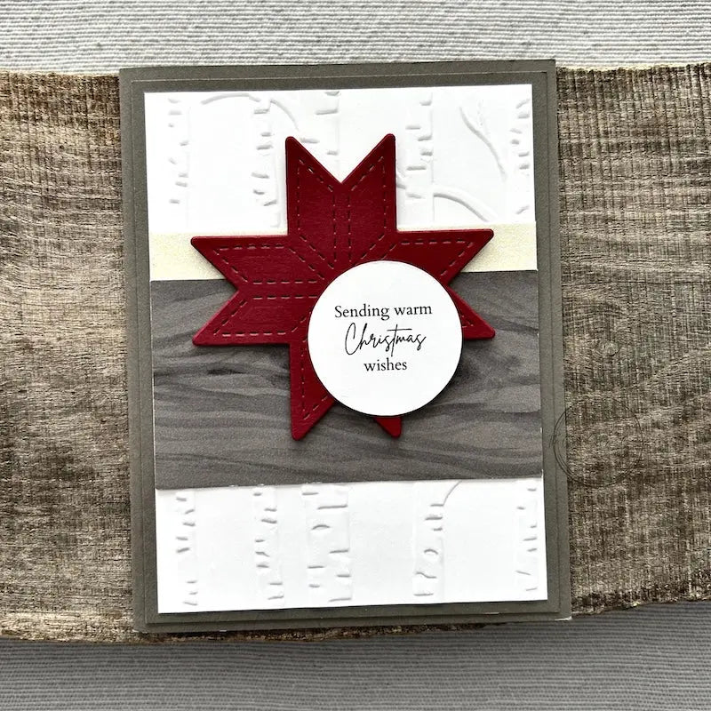 A finished card, from this card making kit, sitting on a wooden board.