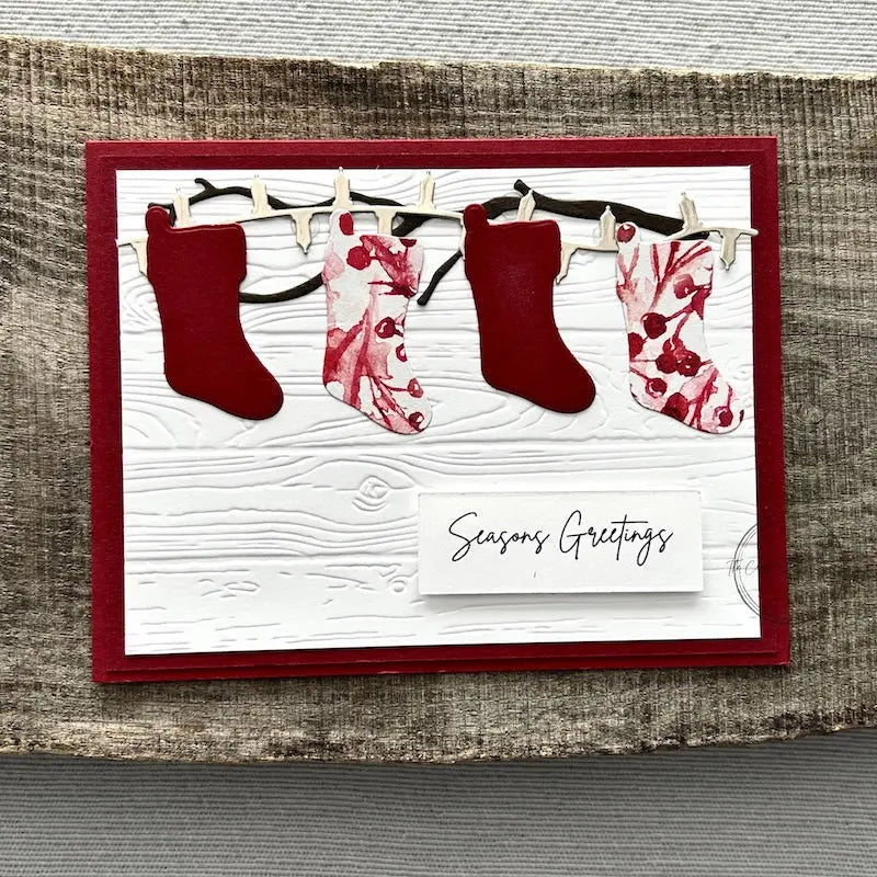 A finished card, from this card making kit, sitting on a wooden board.