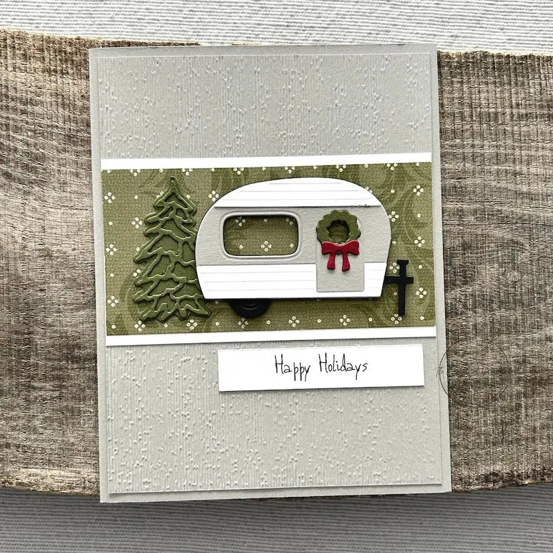 A finished card, from this card making kit, sitting on a wooden board.