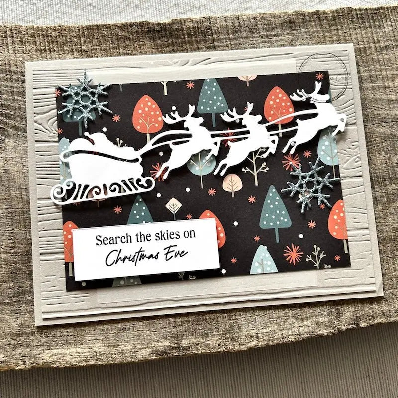 A finished card, from this card making kit, sitting on a wooden board.