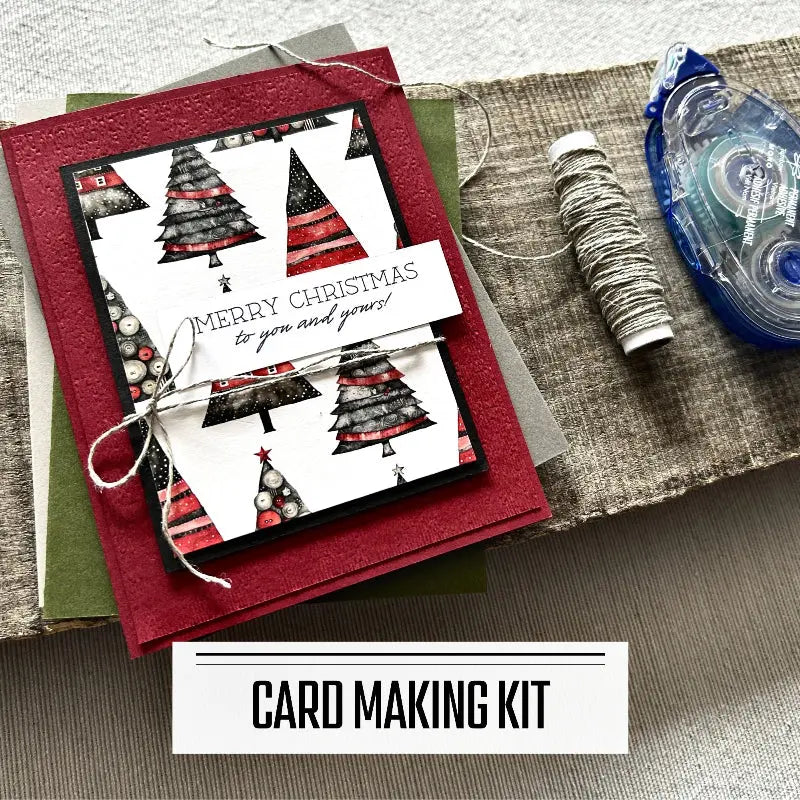 A DIY card making kit for Christmas. A finished card is sitting on blank cards with a roll of twine and a tape runner.