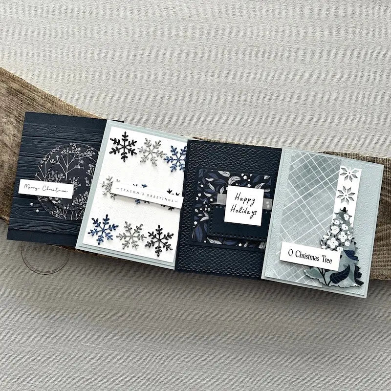There are 4 finished cards, sitting on a wooden board, to show the finished cards that are included in this card making kit.
