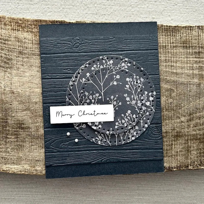A finished card, from this card making kit, sitting on a wooden board.