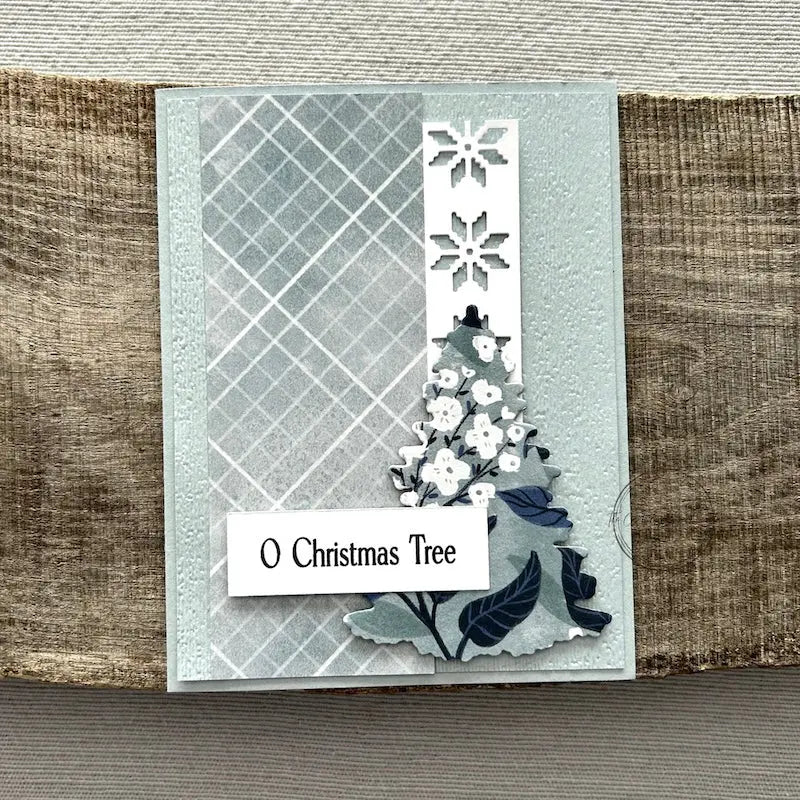 A finished card, from this card making kit, sitting on a wooden board.