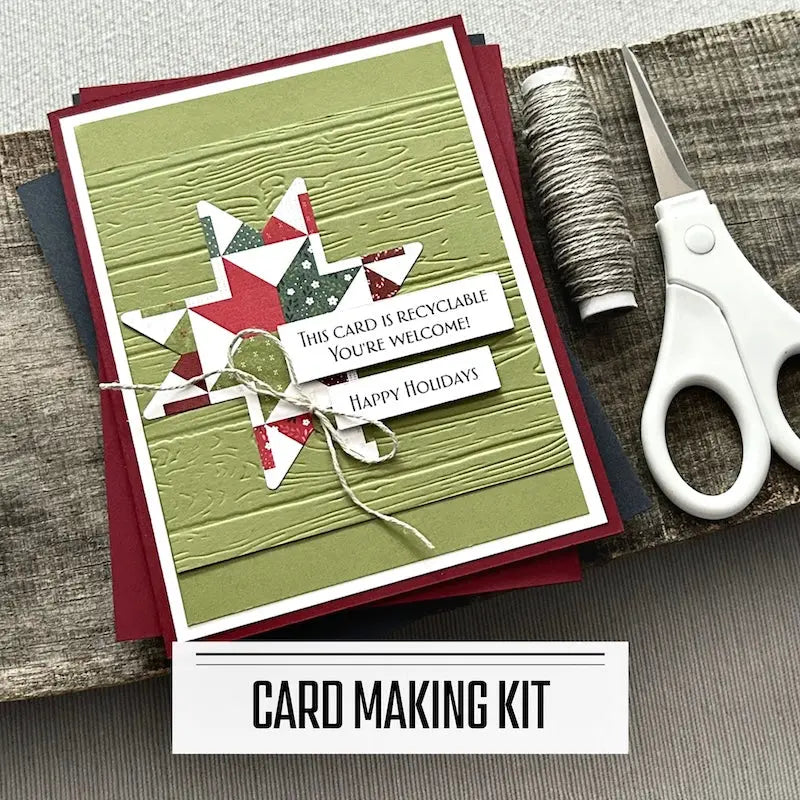 A DIY card making kit for Christmas. A finished card is sitting on blank cards with a roll of twine and scissors.