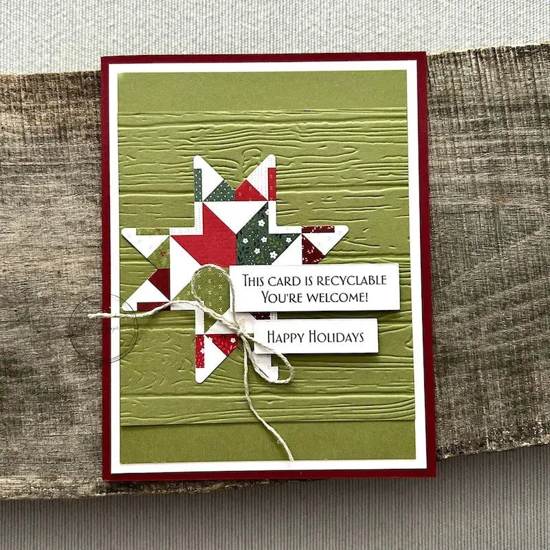A finished card, from this card making kit, sitting on a wooden board.