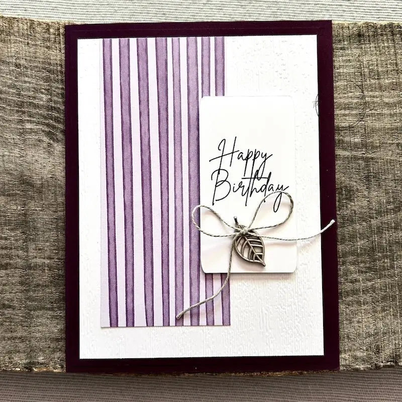 A finished card, from this card making kit, sitting on a wooden board.