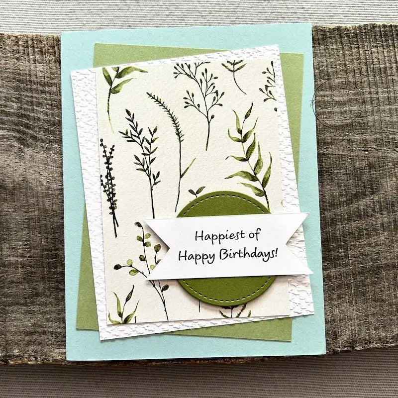 A finished card, from this card making kit, sitting on a wooden board.