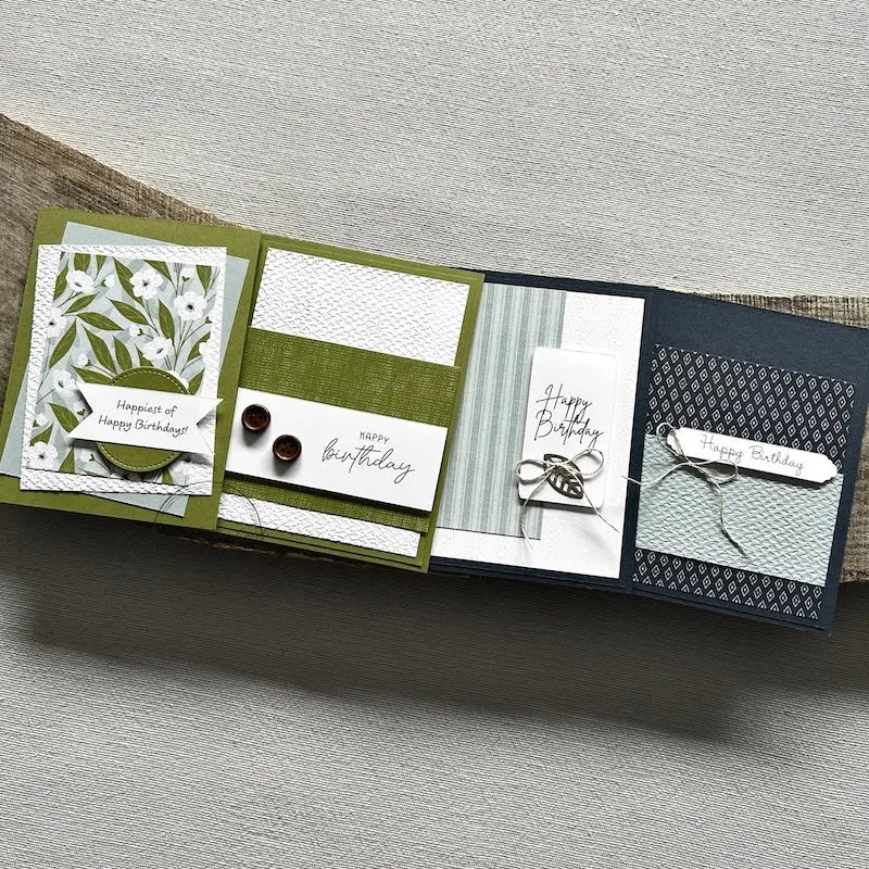 There are 4 finished cards, sitting on a wooden board, to show the finished cards that are included in this card making kit.