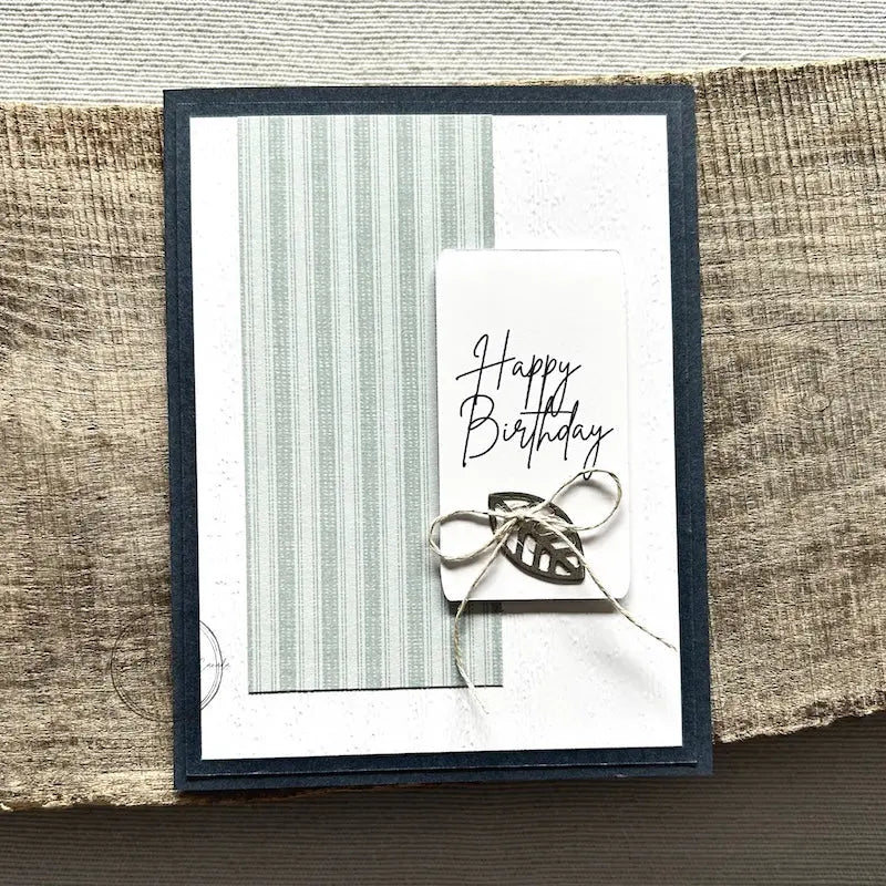 A finished card, from this card making kit, sitting on a wooden board.