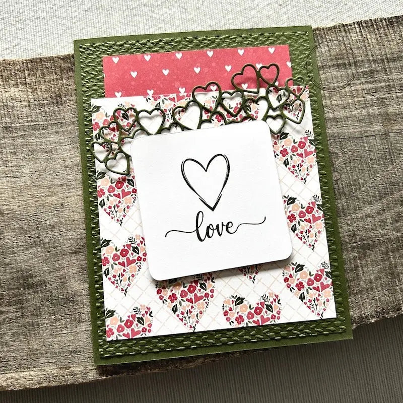 A finished card, from this card making kit, sitting on a wooden board.