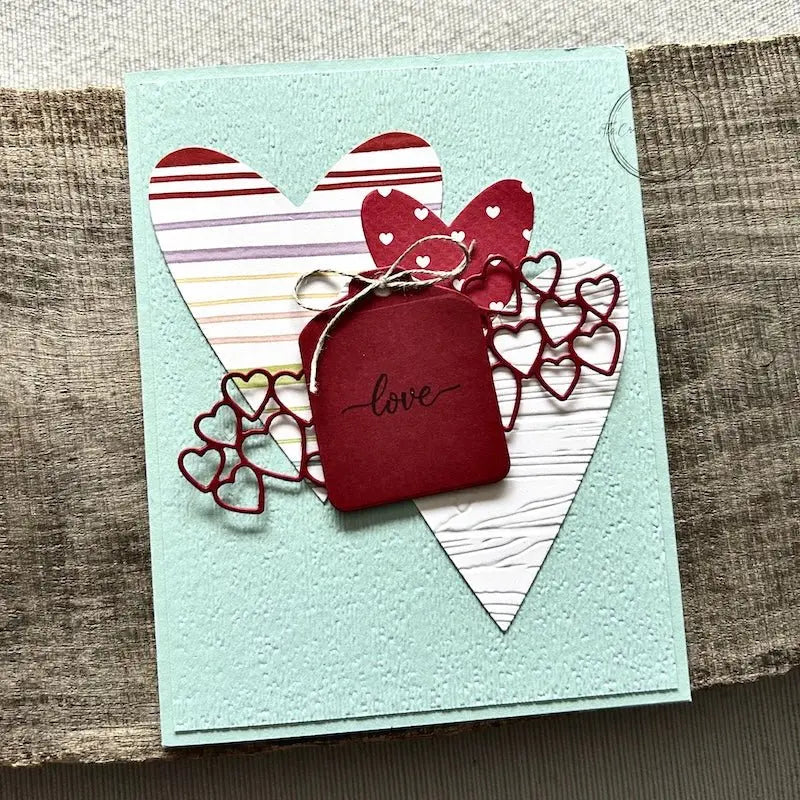 A finished card, from this card making kit, sitting on a wooden board.