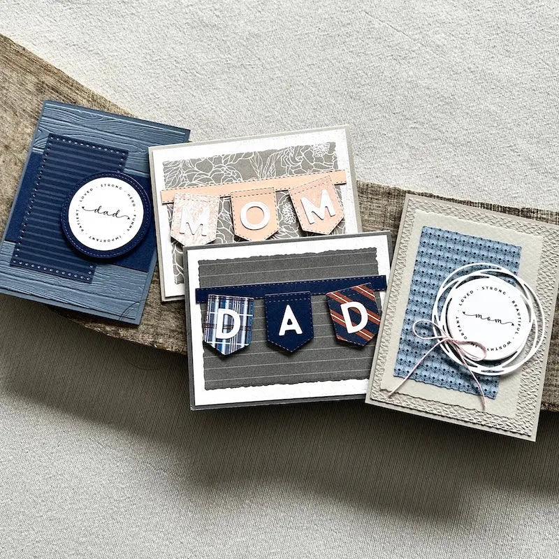 There are 4 finished cards, sitting on a wooden board, to show the finished cards that are included in this card making kit.