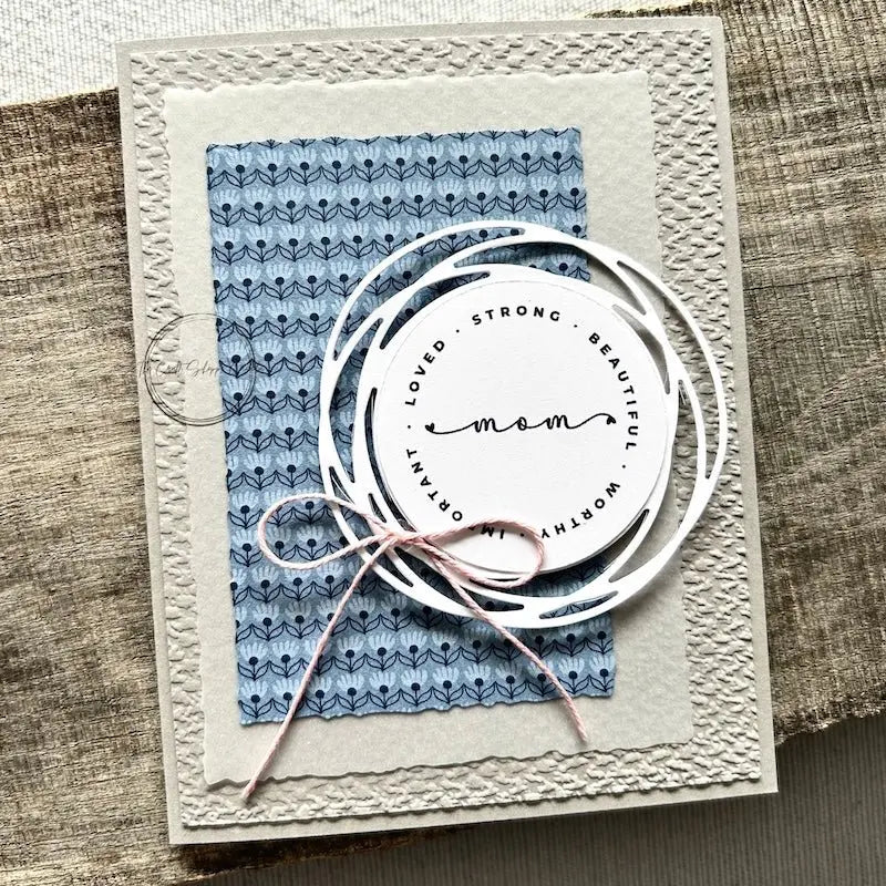 A finished card, from this card making kit, sitting on a wooden board.