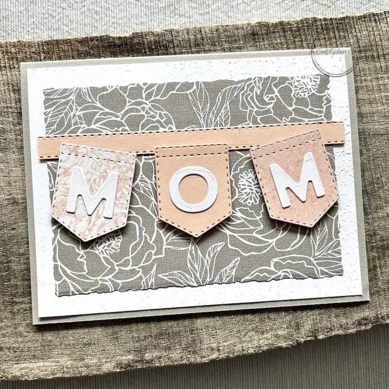 A finished card, from this card making kit, sitting on a wooden board.