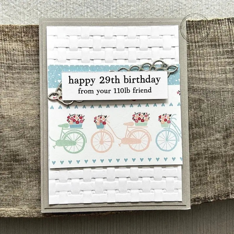 A finished card, from this card making kit, sitting on a wooden board.