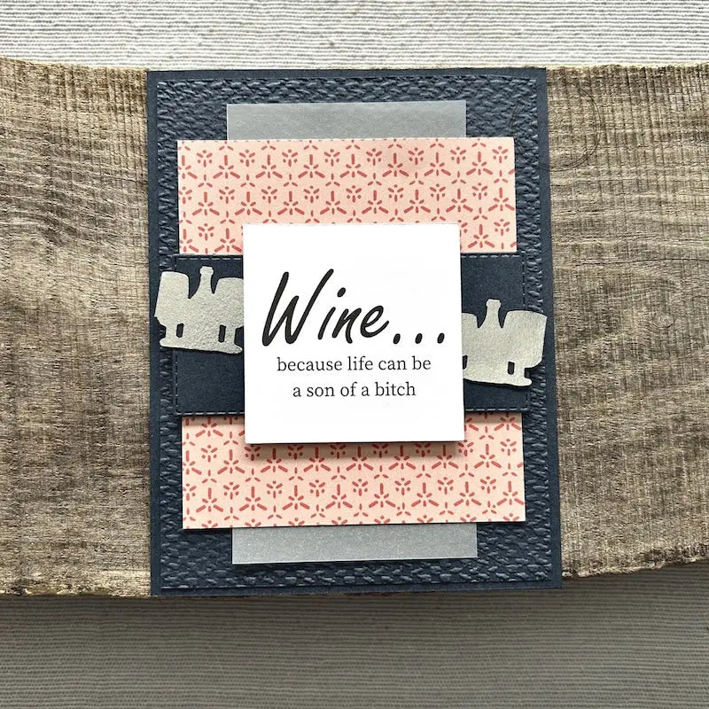 A finished card, from this card making kit, sitting on a wooden board.