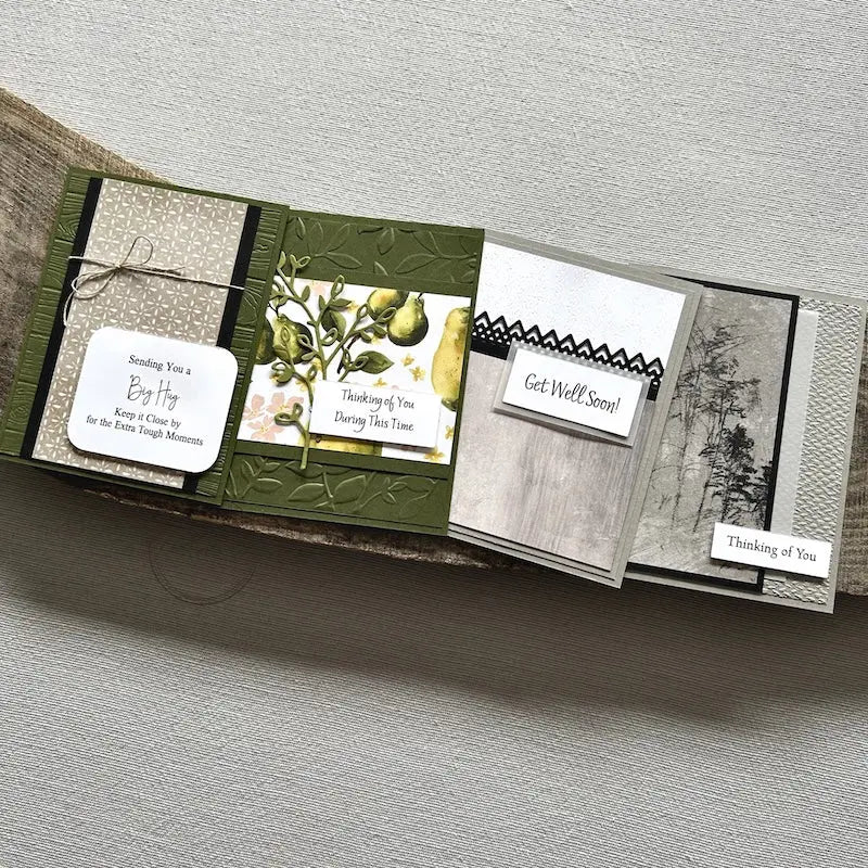 There are 4 finished cards, sitting on a wooden board, to show the finished cards that are included in this card making kit.