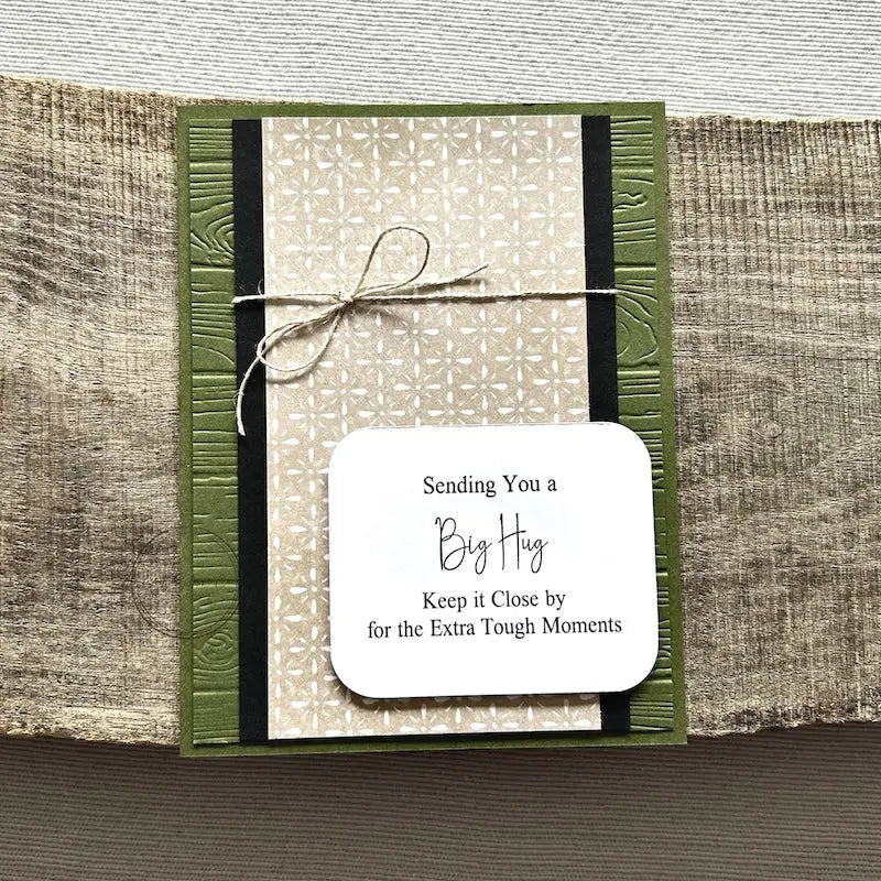 A finished card, from this card making kit, sitting on a wooden board.