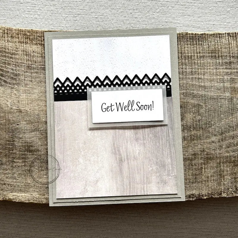 A finished card, from this card making kit, sitting on a wooden board.