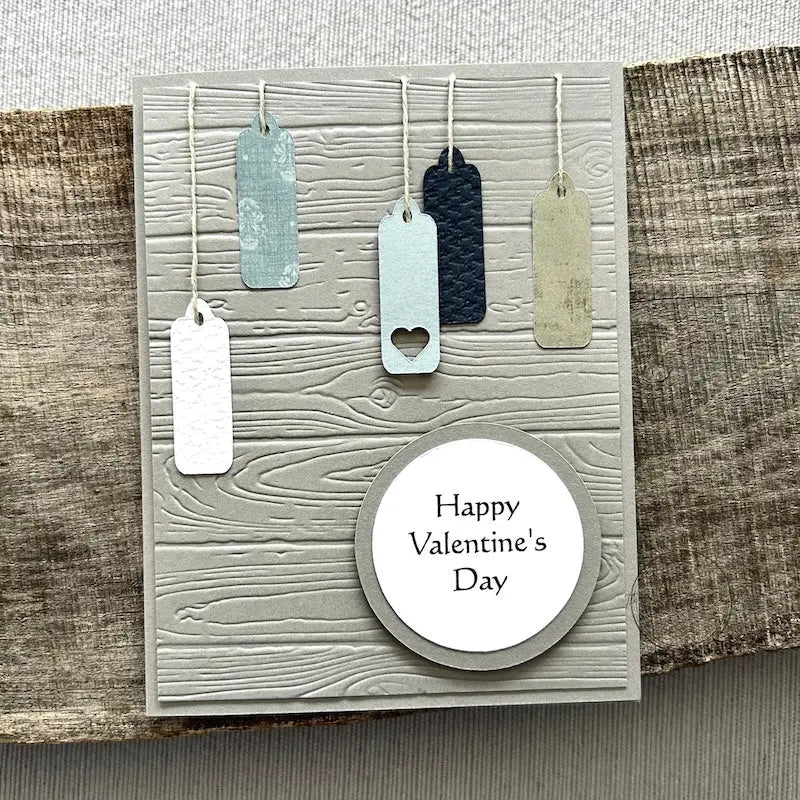 A finished card, from this card making kit, sitting on a wooden board.