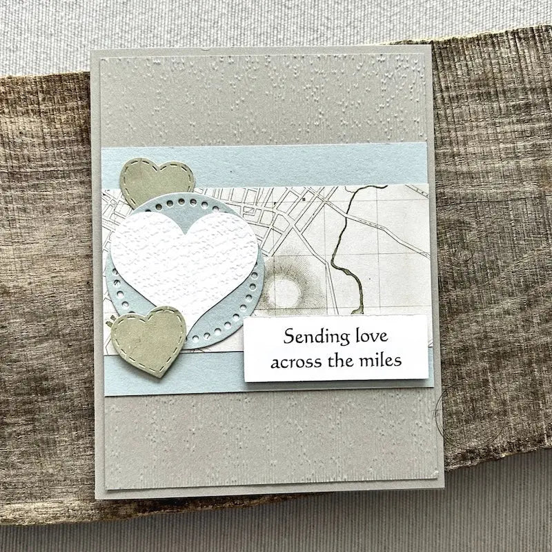 A finished card, from this card making kit, sitting on a wooden board.