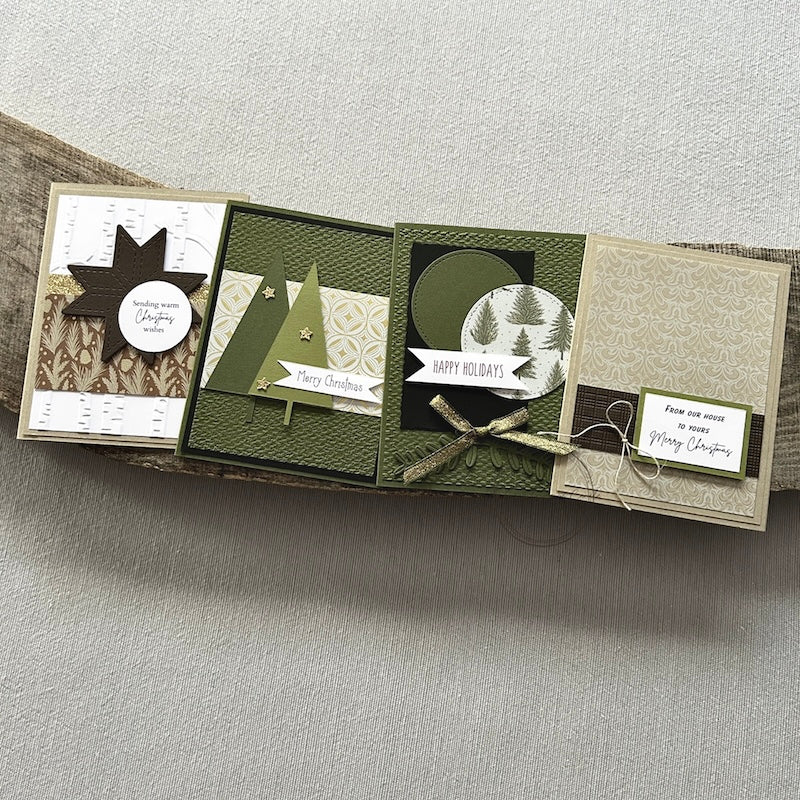 There are 4 finished cards, sitting on a wooden board, to show the finished cards that are included in this card making kit.