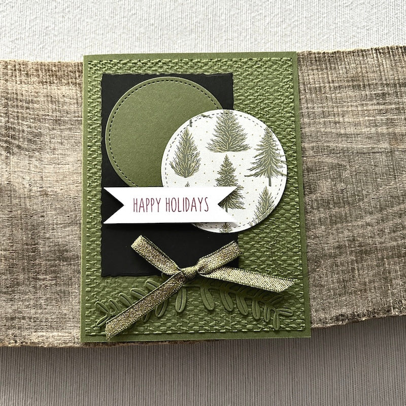 A finished card, from this card making kit, sitting on a wooden board.