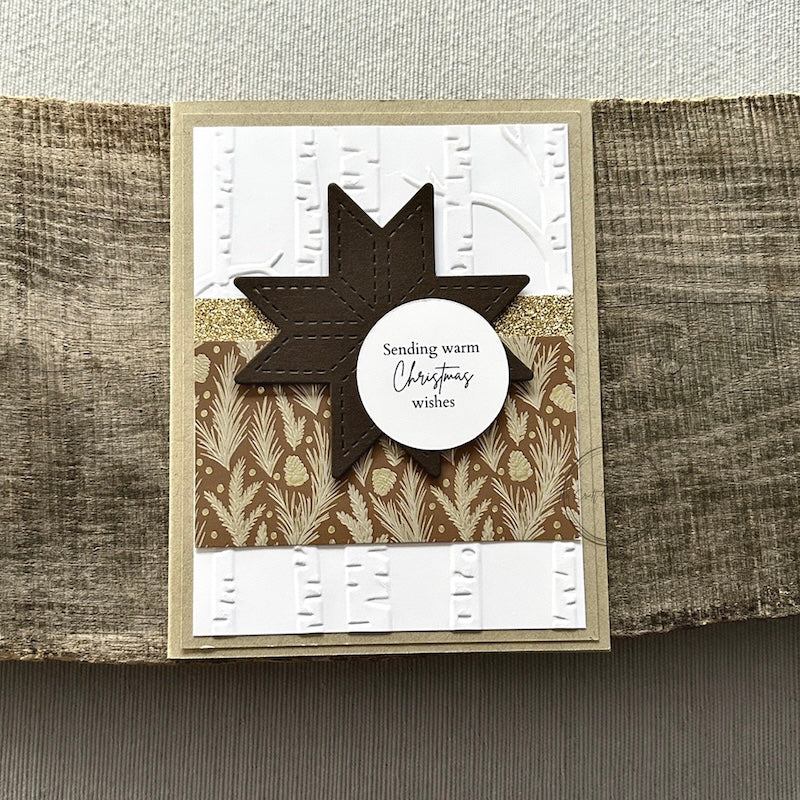 A finished card, from this card making kit, sitting on a wooden board.