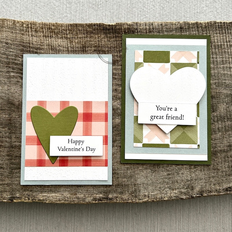 Finished Valentines, from this card making kit, sitting on a wooden board.