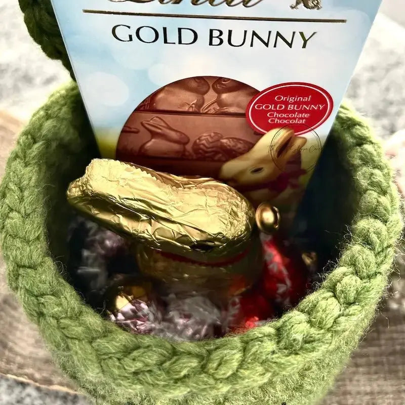 A look at the inside of the green bunny basket filled with chocolate.