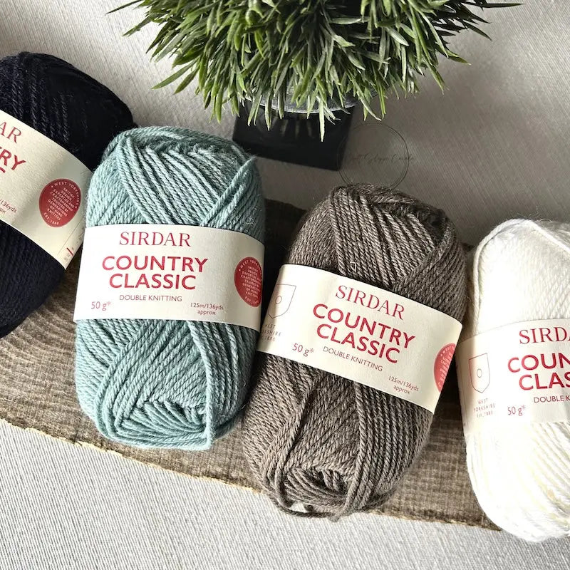 The yarn used in this crochet kit, is lying on a wooden board.