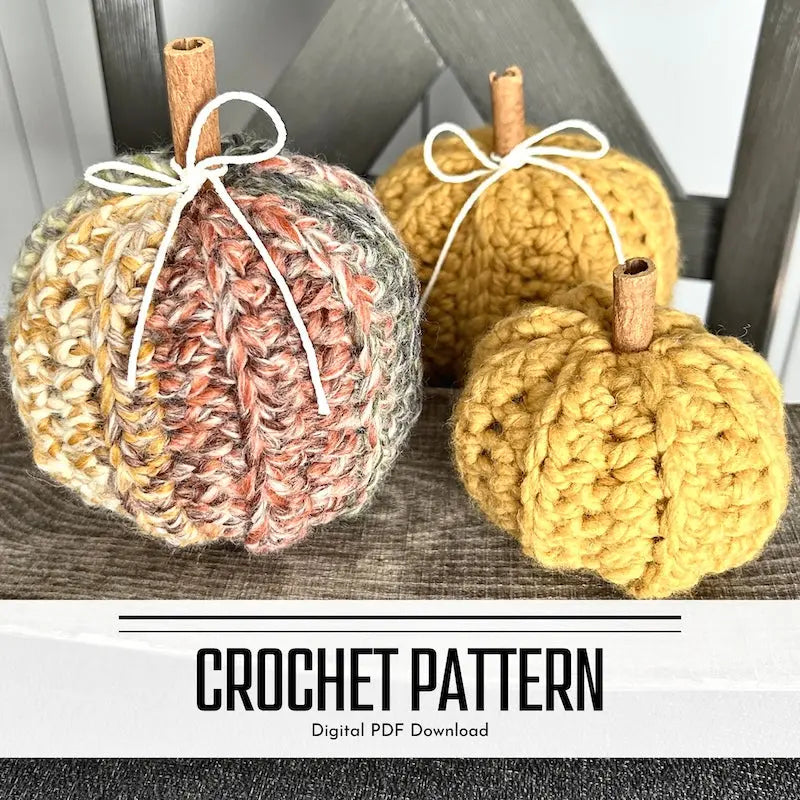 A digital PDF crochet pattern for a set of autumn pumpkins. The pumpkins are lying over a wooden table on a chair.