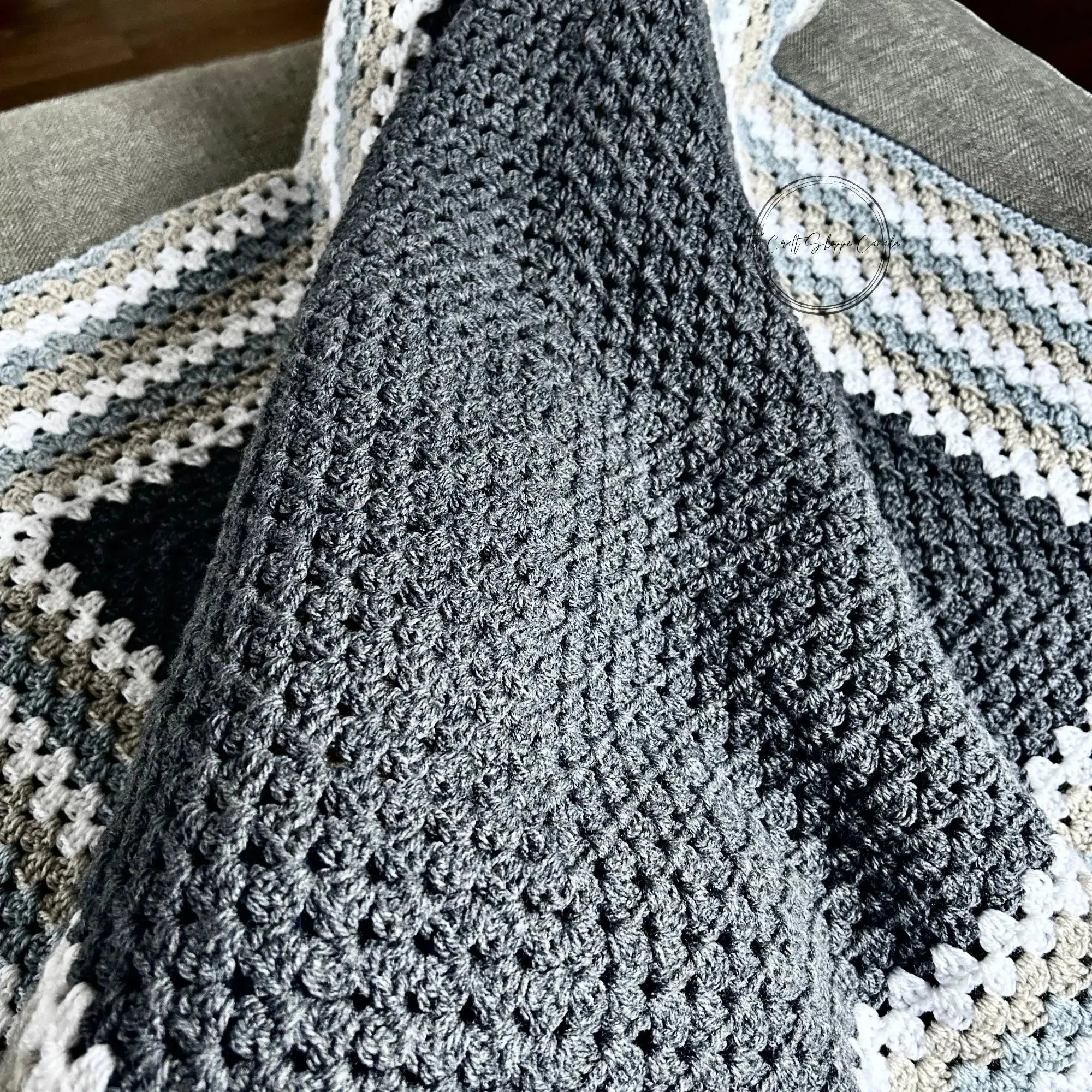The finished blanket, from this crochet pattern is on someone's lap.