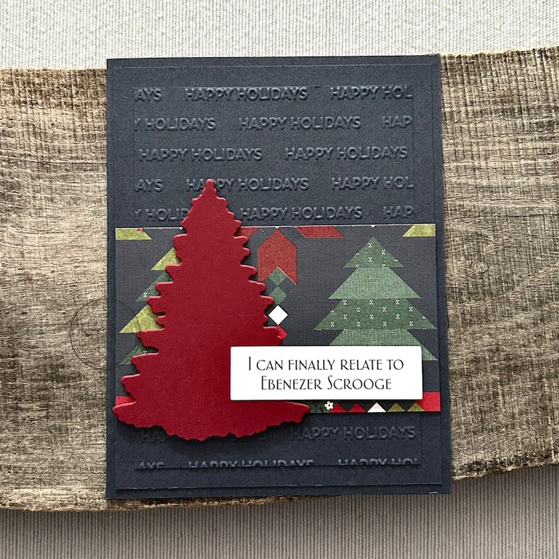 A finished card, from this card making kit, sitting on a wooden board.