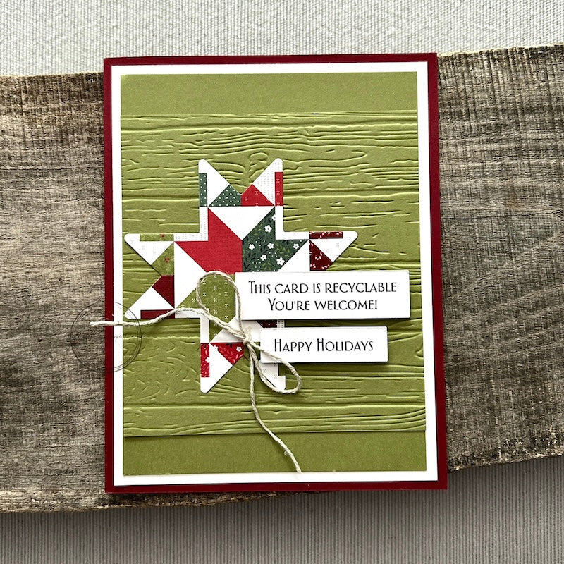 A finished card, from this card making kit, sitting on a wooden board.