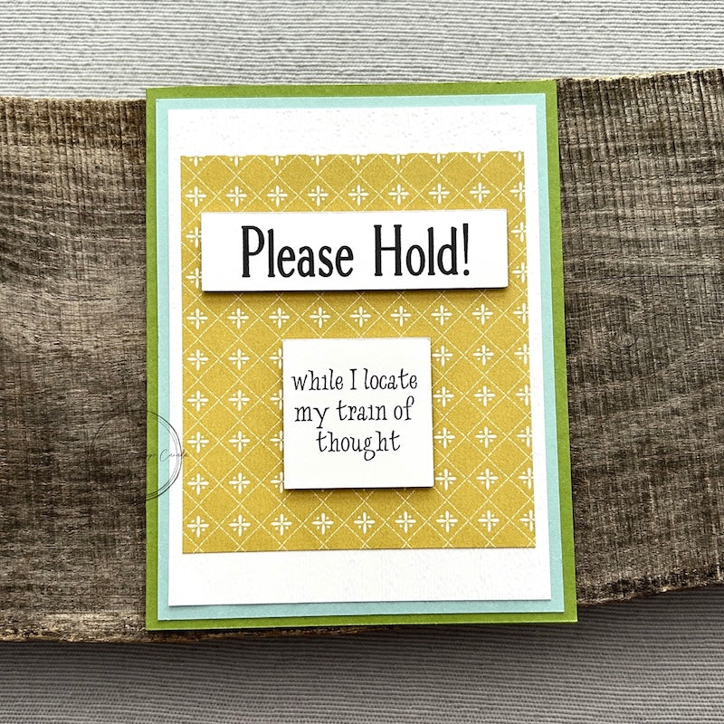 A finished card, from this card making kit, sitting on a wooden board.