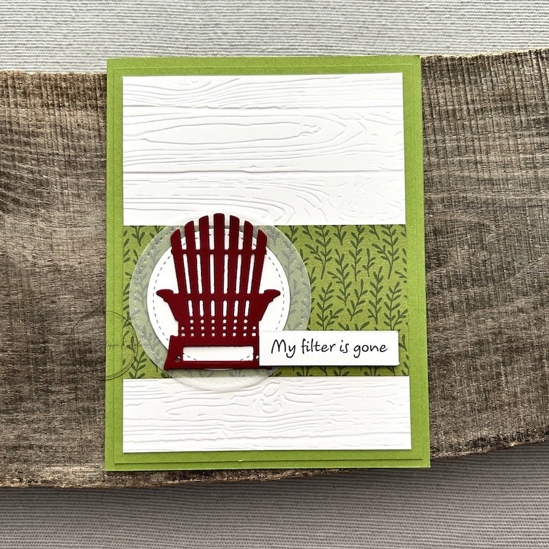 A finished card, from this card making kit, sitting on a wooden board.