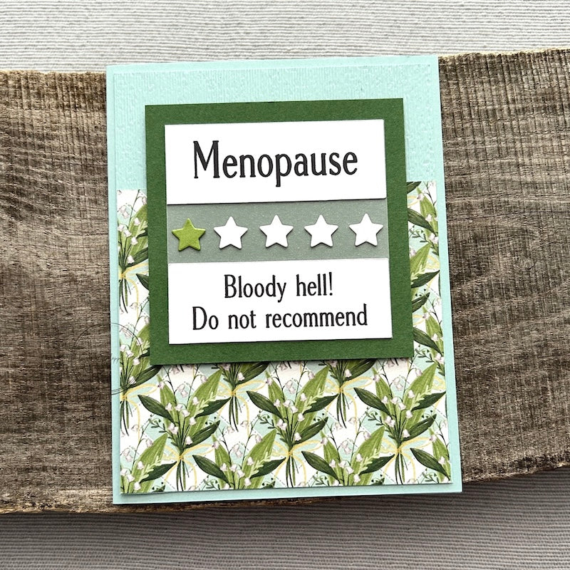 A finished card, from this card making kit, sitting on a wooden board.
