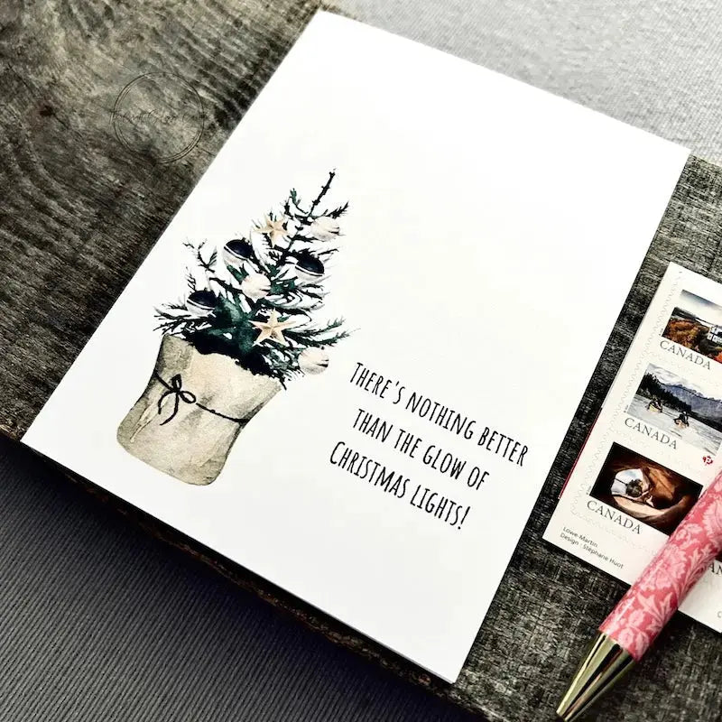 The printable greeting card is sitting on a wooden board with a pen and stamps.