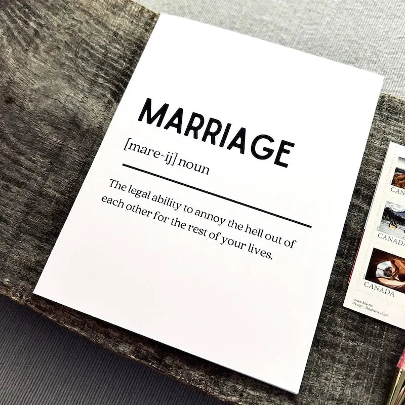 The printable greeting card is sitting on a wooden board with a pen and stamps.